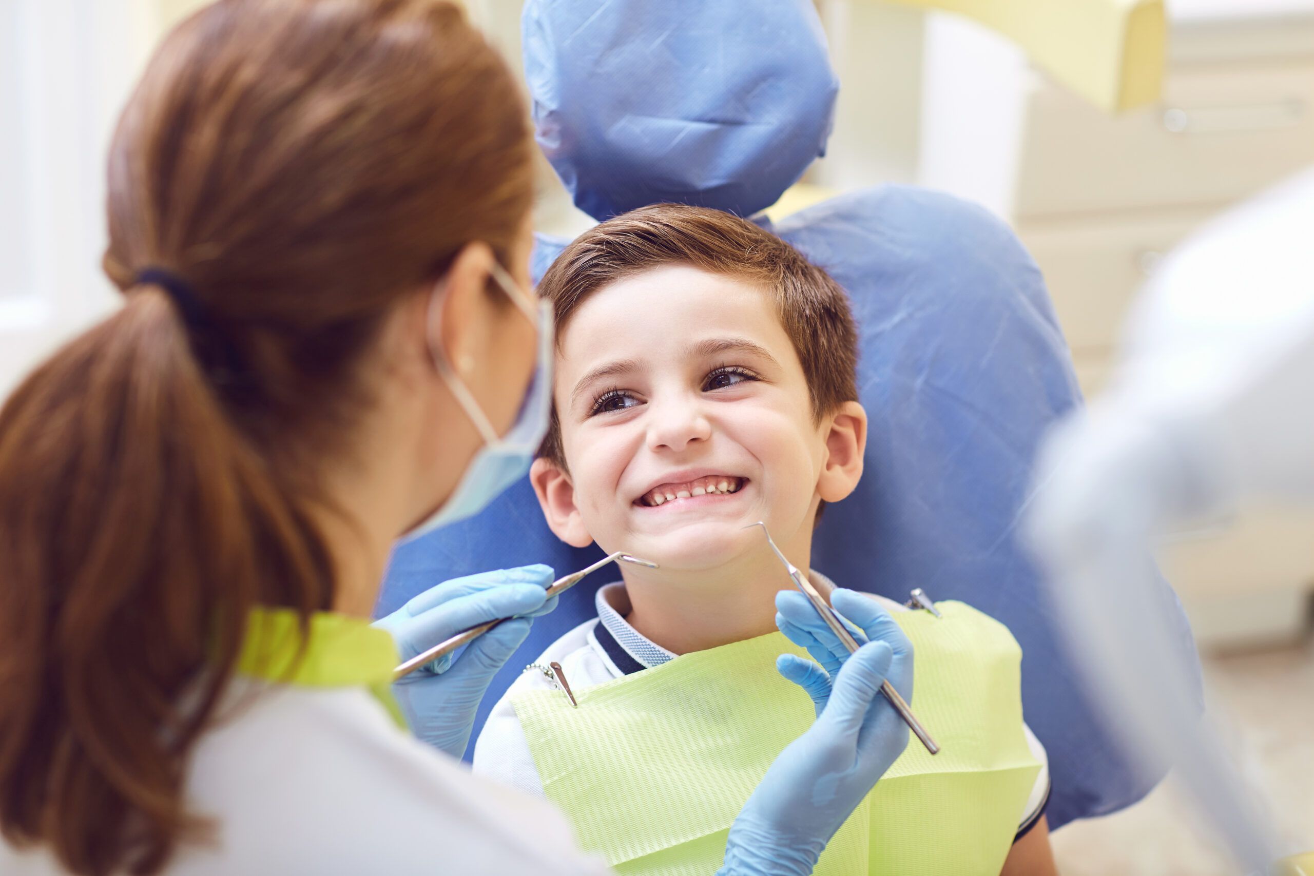 pediatric dentist helping child smile and feel calm in dental chair