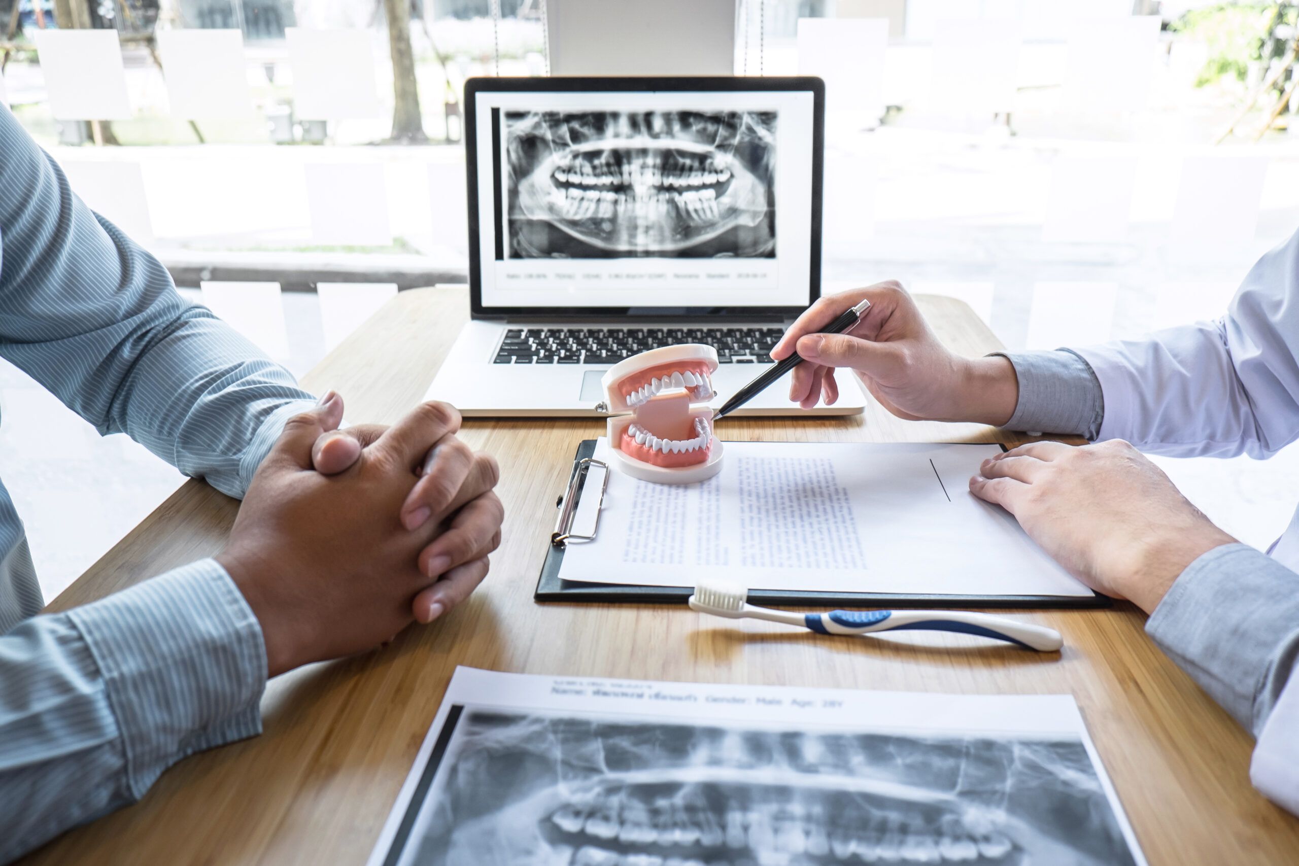 oral surgeon and patient discussing surgery plans with xray